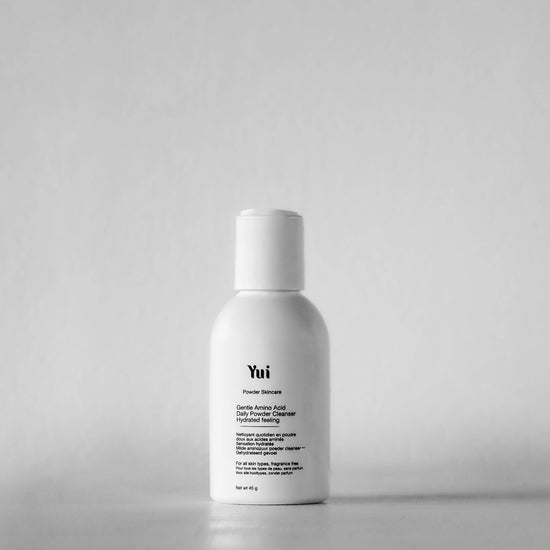 Yui Powder Face Cleanser bottle on white background